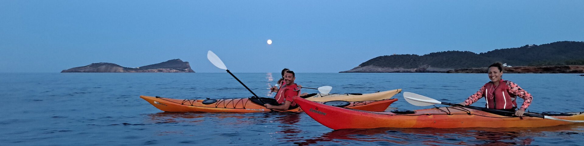 People in kayaks watching the full moon