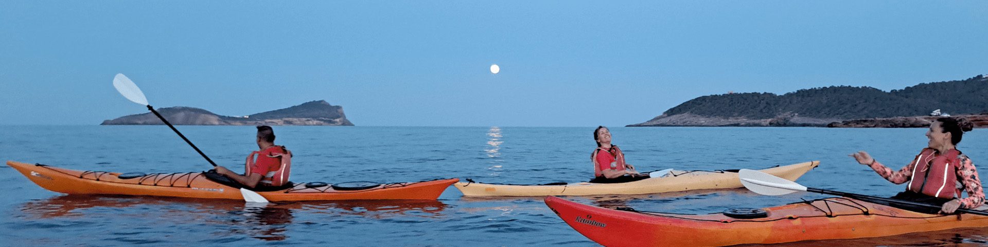 People in kayaks watching the full moon