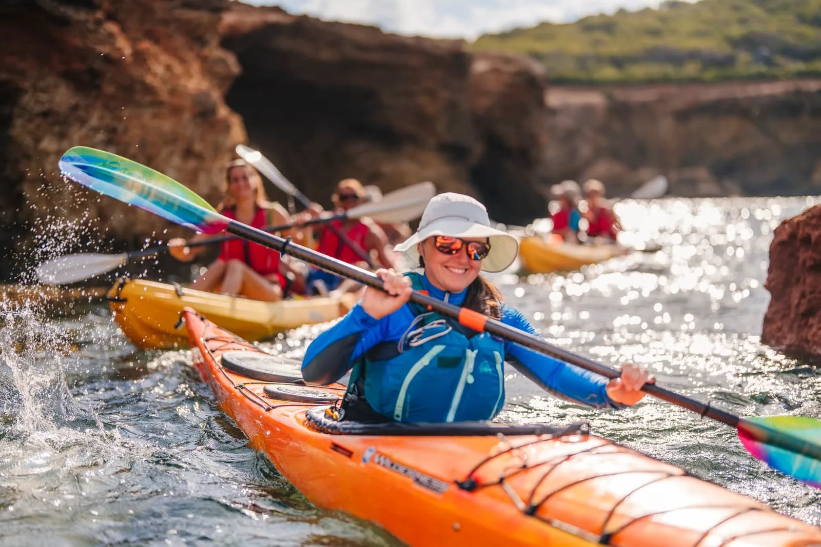 Group kayaking along the rocky coast of Ibiza