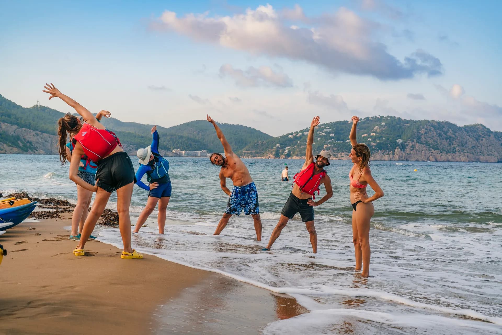 SUP and yoga wellness session on the beach at sunset
